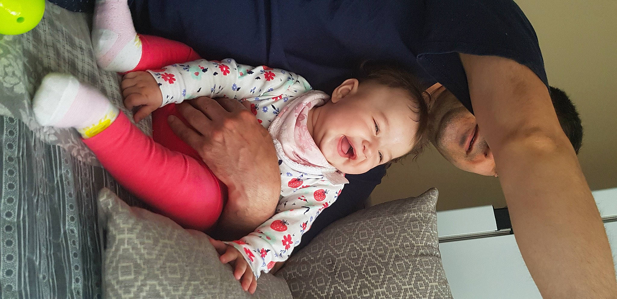 Fiona is registered to the contest to win money with this photo: arm, baby, baby_toddler_clothing, cheek, comfort, elbow, finger, flash_photography, glasses, human_body, joint, knee, lip, mouth, person, skin, sleeve, smile, thigh, toddler