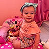 Erica joined the competition — help win amazing prizes! bow, child, clothing, cushion, daisy_duck, floral_shorts, footwear, happy, headband, indoors, minnie_mouse, person, pink_curtain, pink_wall, polka_dot, portrait, sitting, smiling, toddler, toy
