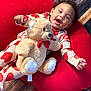 Jordan joined the competition — help win amazing prizes! baby, toddler, child, pajamas, hearts, teddy_bear, plush_toy, red, cushion, fabric, floor, wood, smiling, happy, indoor, person, cute, cozy, comfort, playful