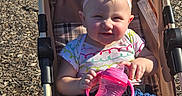Sage joined the competition — help win amazing prizes! baby, child, stroller, sippy_cup, headband, bow, outdoor, playground, sunlight, wood_chips, clothing, shorts, smile, person, seat, mesh, fabric, hand, legs, happy