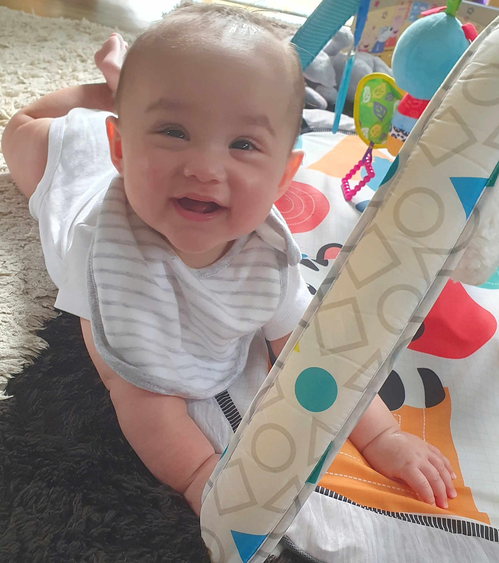 Anastasia joined the competition — help win amazing prizes! baby, smiling, play_mat, toy, carpet, infant, child, happy, indoors, clothing, bib, cute, face, hand, bright, colorful, young, person, soft_toys, floor