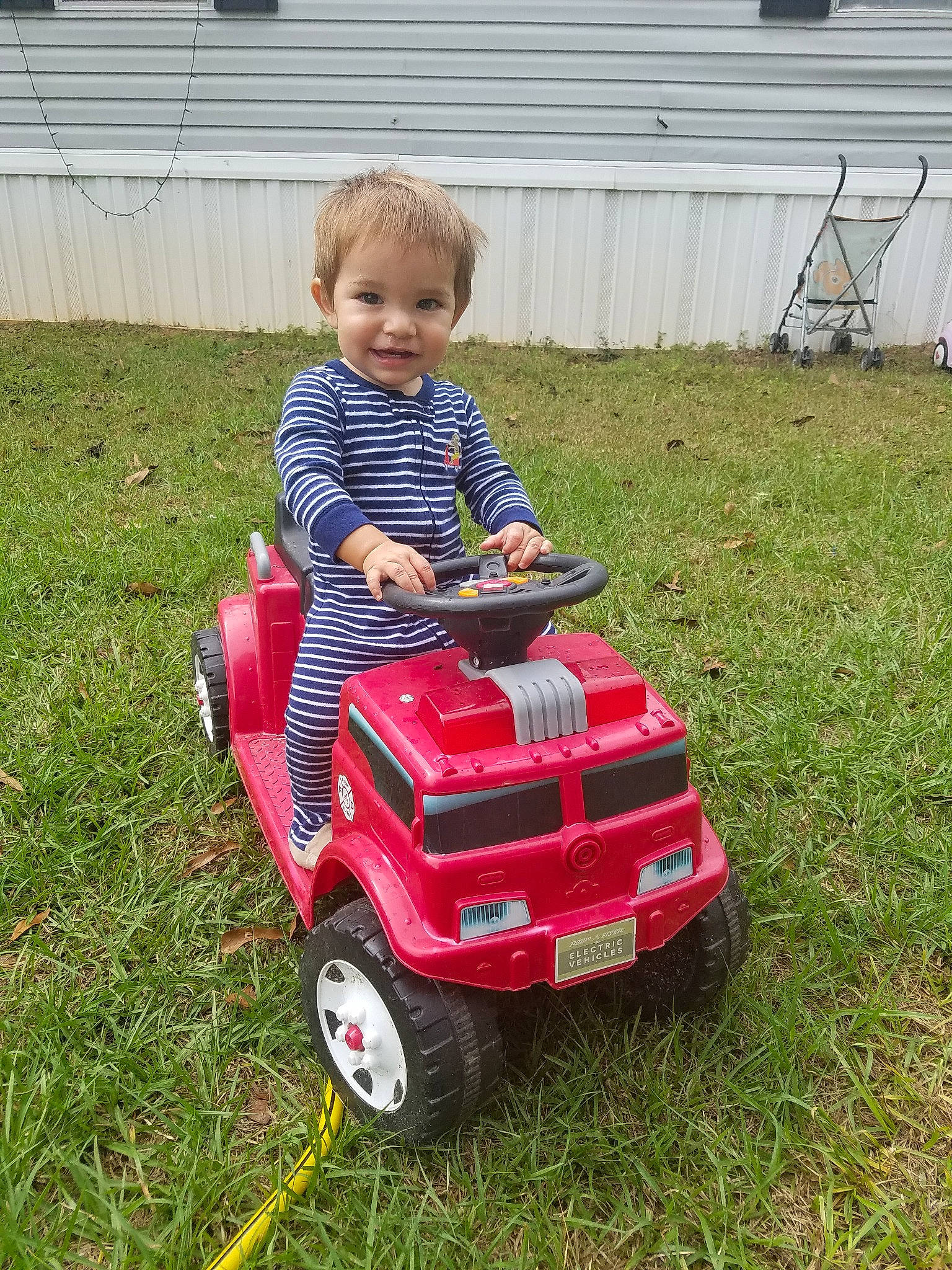 Conrad is registered to the contest to win money with this photo: backyard, car, child, city_car, fun, garden, grass, joy, lawn, mower, outdoor_power_equipment, person, plant, play, riding_toy, toddler, tool, toy, vehicle, yard