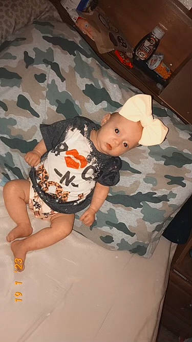 Mckenzie joined the competition — help win amazing prizes! baby, baby_products, baby_toddler_clothing, child, comfort, fun, human_leg, knee, linens, mammal, military_camouflage, pattern, person, room, sitting, sleeve, t_shirt, thigh, toddler, vertebrate