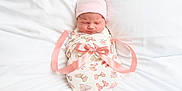 Everlee is registered to the contest to win money with this photo: newborn, baby, swaddled, blanket, pink_hat, ribbon, bow, sleeping, infant, bed, white_bed, soft, peaceful, cute, portrait, child, face, pattern, butterfly, cozy
