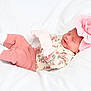 adorable, baby, child, cozy, cute, floral_pattern, flower_headband, headwear, indoors, infant, laying_down, newborn, peaceful, pink_clothing, portrait, resting, sleeping, small, soft_texture, white_blanket