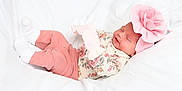 Everlee is registered to the contest to win money with this photo: adorable, baby, child, cozy, cute, floral_pattern, flower_headband, headwear, indoors, infant, laying_down, newborn, peaceful, pink_clothing, portrait, resting, sleeping, small, soft_texture, white_blanket