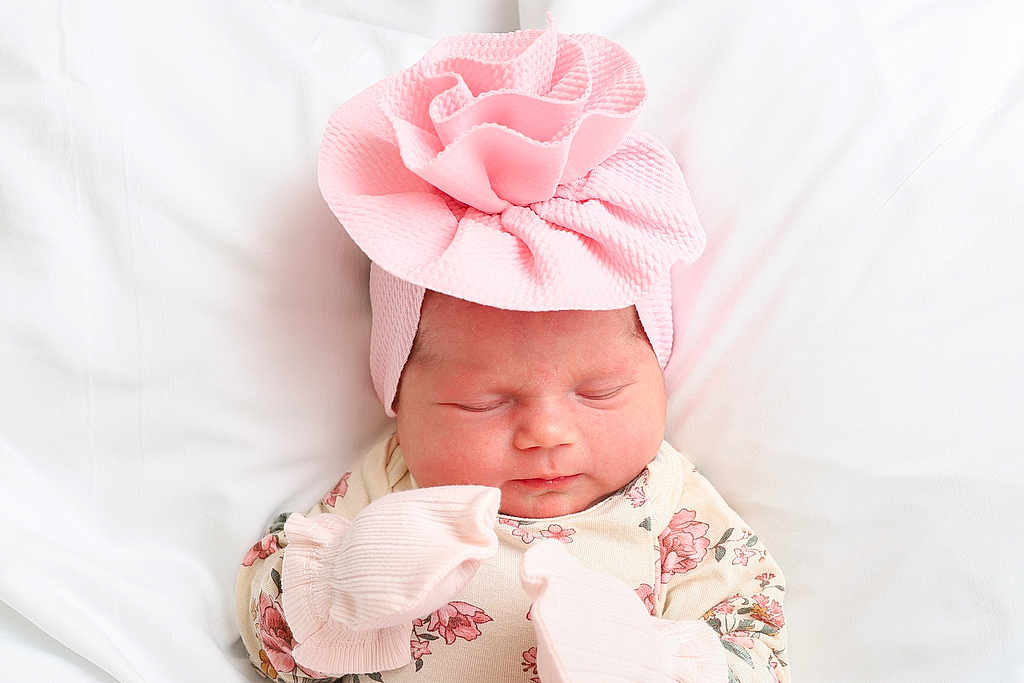 Everlee is registered to the contest to win money with this photo: newborn, baby, sleeping, pink_hat, floral_clothing, mittens, soft_texture, white_background, infant, cute, peaceful, portrait, headwear, child, resting, indoors, closeup, small, adorable, sleep