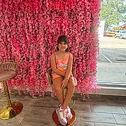 Nathaly joined the competition — help win amazing prizes! casual_clothing, chair, child, daylight, decor, floor_tiles, flower_wall, girl, greenery, indoor, nature, outdoor_view, parking_lot, pink_flowers, portrait, seated, smile, sneakers, stool, window