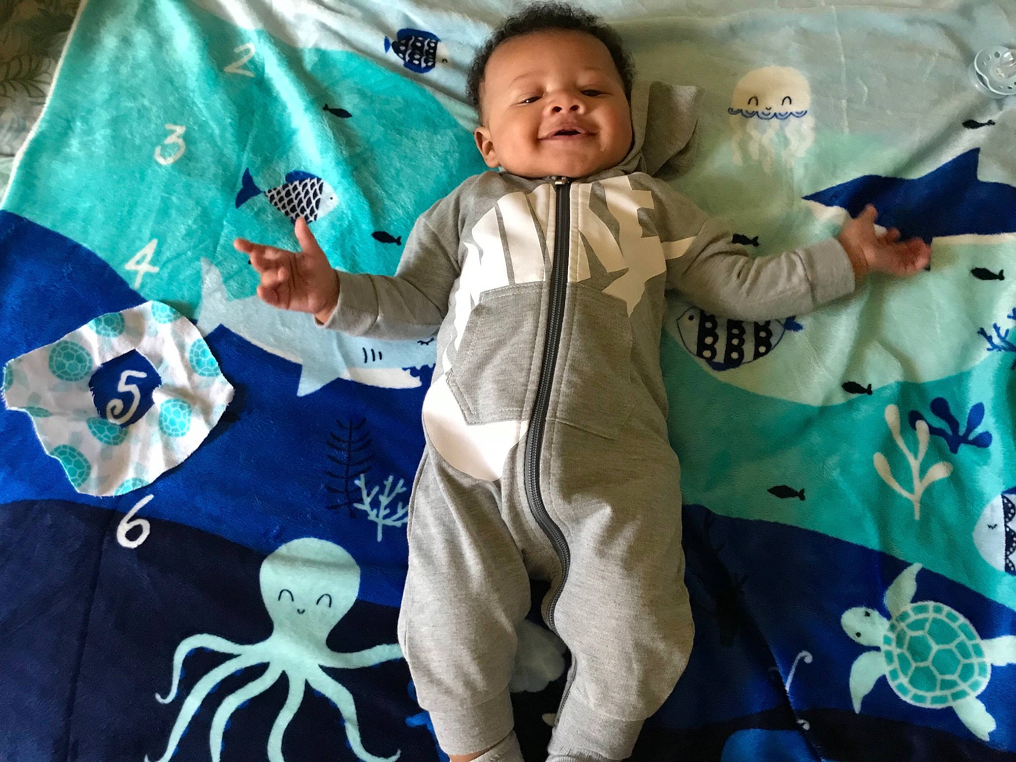 Lorenzo is registered to the contest to win money with this photo: aqua, azure, baby, baby_products, baby_toddler_clothing, bedding, child, comfort, electric_blue, event, green, happy, joy, linens, pattern, person, room, sleeve, smile, t_shirt