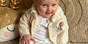 Romane participe au concours pour gagner de l'argent avec cette photo : baby, child, infant, headband, bow, sweater, leggings, shoes, plush_toy, blanket, beige, patterned_clothing, smiling, sitting, cute, indoors, cozy, soft_texture, person, portrait