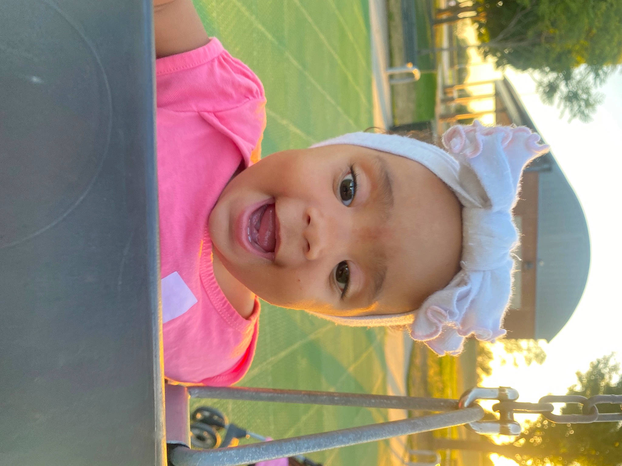 Vailynn is registered to the contest to win money with this photo: baby, baby_products, child, city, fun, grass, happy, hat, house, leisure, lip, magenta, outdoor_play_equipment, person, plant, play, smile, toddler, tree, vacation