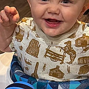 Gage is registered to the contest to win money with this photo: toddler, child, smiling, walker, toy, blue, shirt, indoor, happy, person, face, playful, cute, baby, clothing, young, expression, sitting, fun, bright