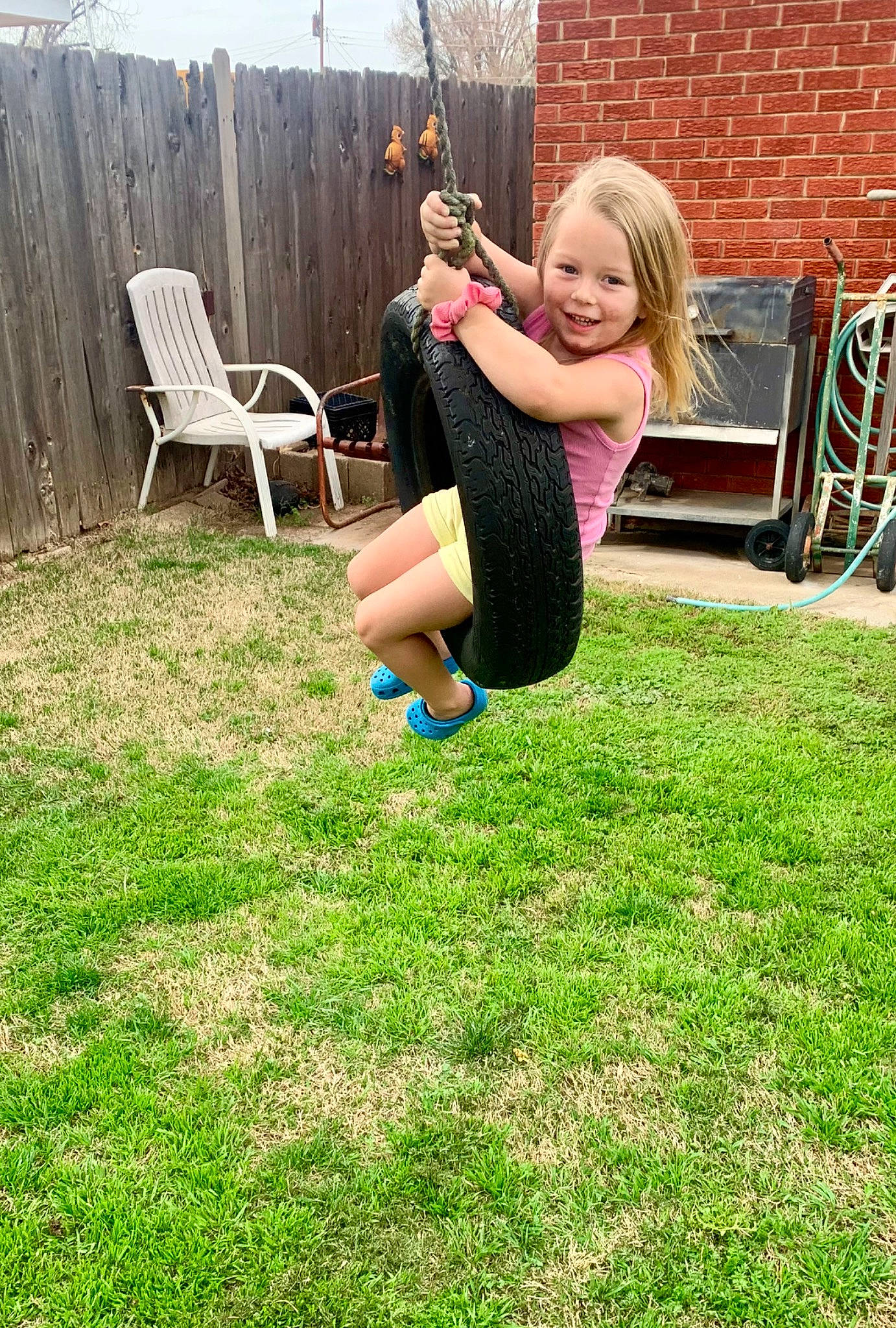 Hendrix is registered to the contest to win money with this photo: barefoot, brickwork, chair, child, clothing, fun, grass, happy, human_leg, joy, knee, lawn, leisure, people_in_nature, person, plant, recreation, smile, spring, summer