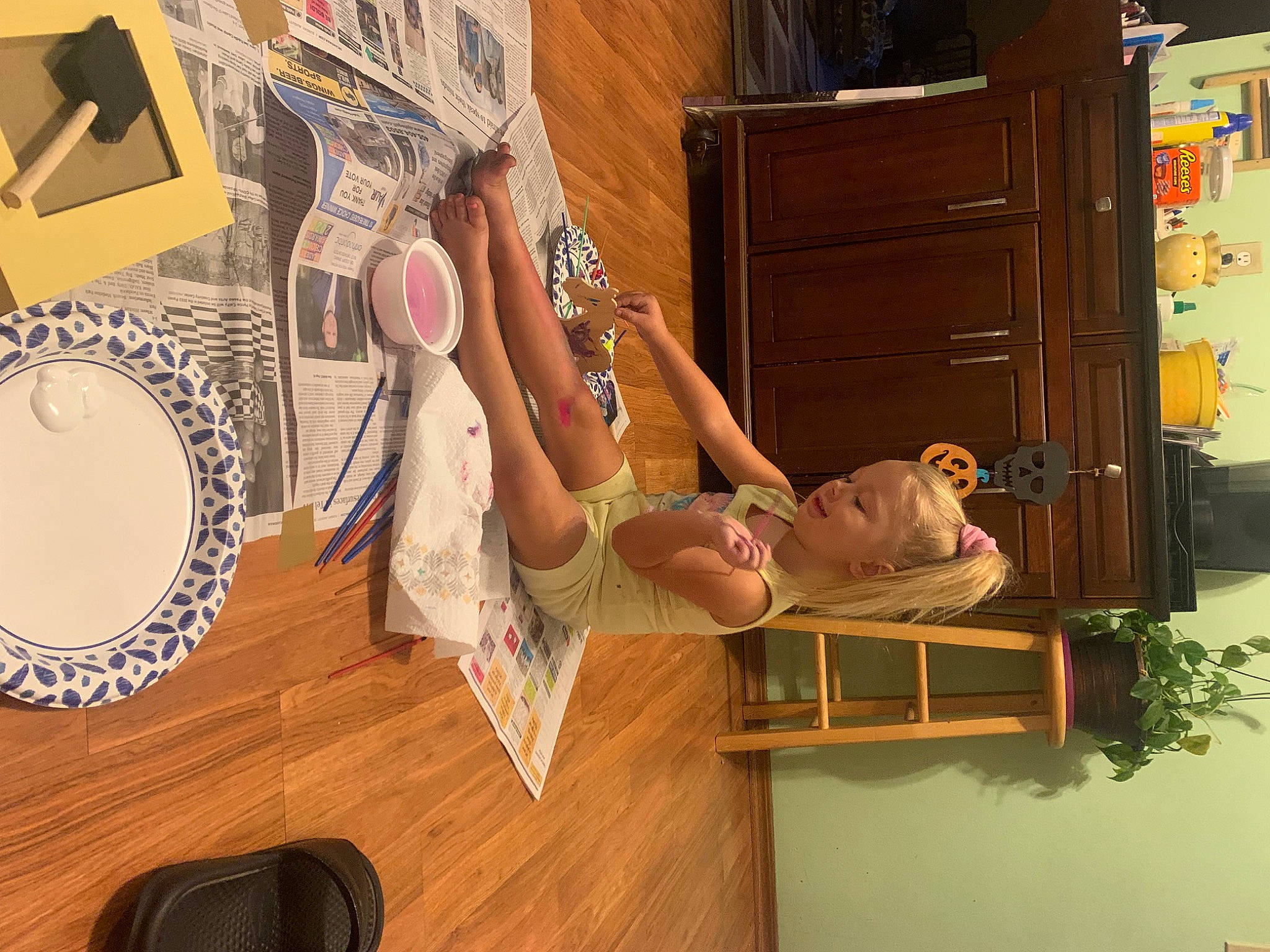 Hendrix is registered to the contest to win money with this photo: art, cabinetry, chair, circle, cupboard, drawer, eyewear, flooring, fun, hardwood, hat, musical_instrument, person, plant, refrigerator, room, shelf, shelving, thigh, wood