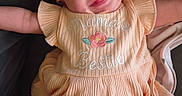 Davina is registered to the contest to win money with this photo: apparel, arms_outstretched, baby, child, cute, dress, embroidery, fabric, face, happy, headband, headwear, indoors, infant, lying_down, peach_color, person, portrait, smiling, young_child