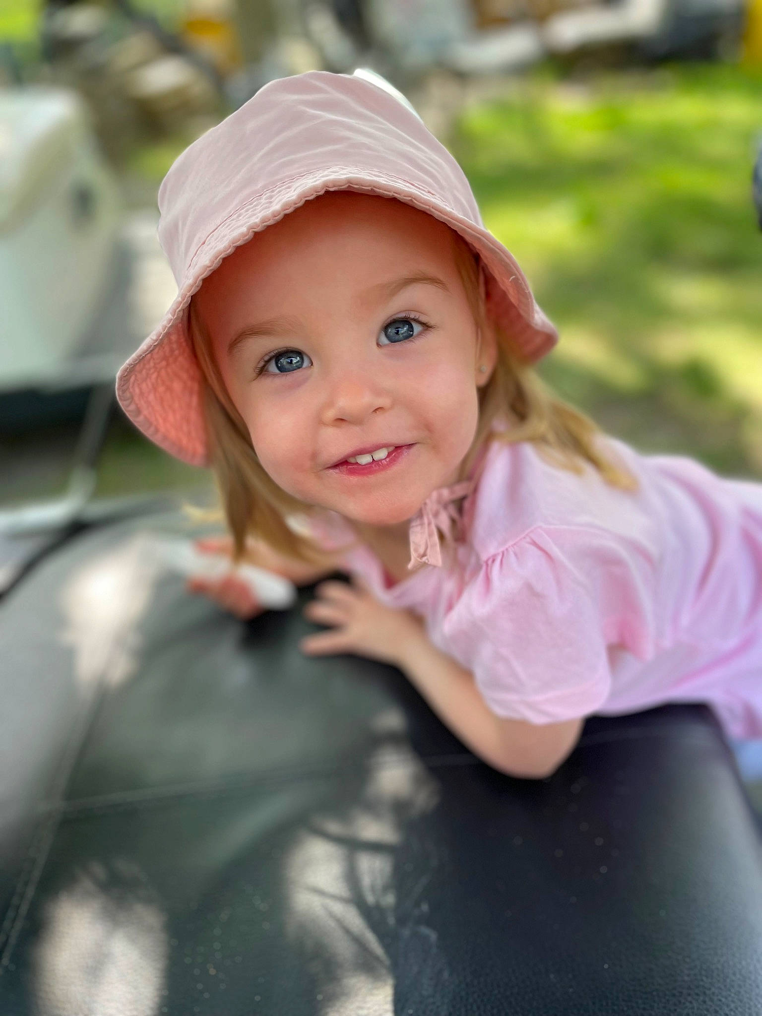 Lyvia participe au concours pour gagner de l'argent avec cette photo : blond, cap, child, cool, fashion_accessory, flash_photography, fun, grass, happy, hat, headwear, joy, leisure, lip, people_in_nature, person, pink, recreation, sitting, smile