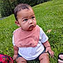 Maverick is registered to the contest to win money with this photo: baby, child, grass, outdoor, greenery, bib, white_shirt, sitting, curious, backpack, hand, person, nature, park, shorts, young_child, daylight, casual, cute, face