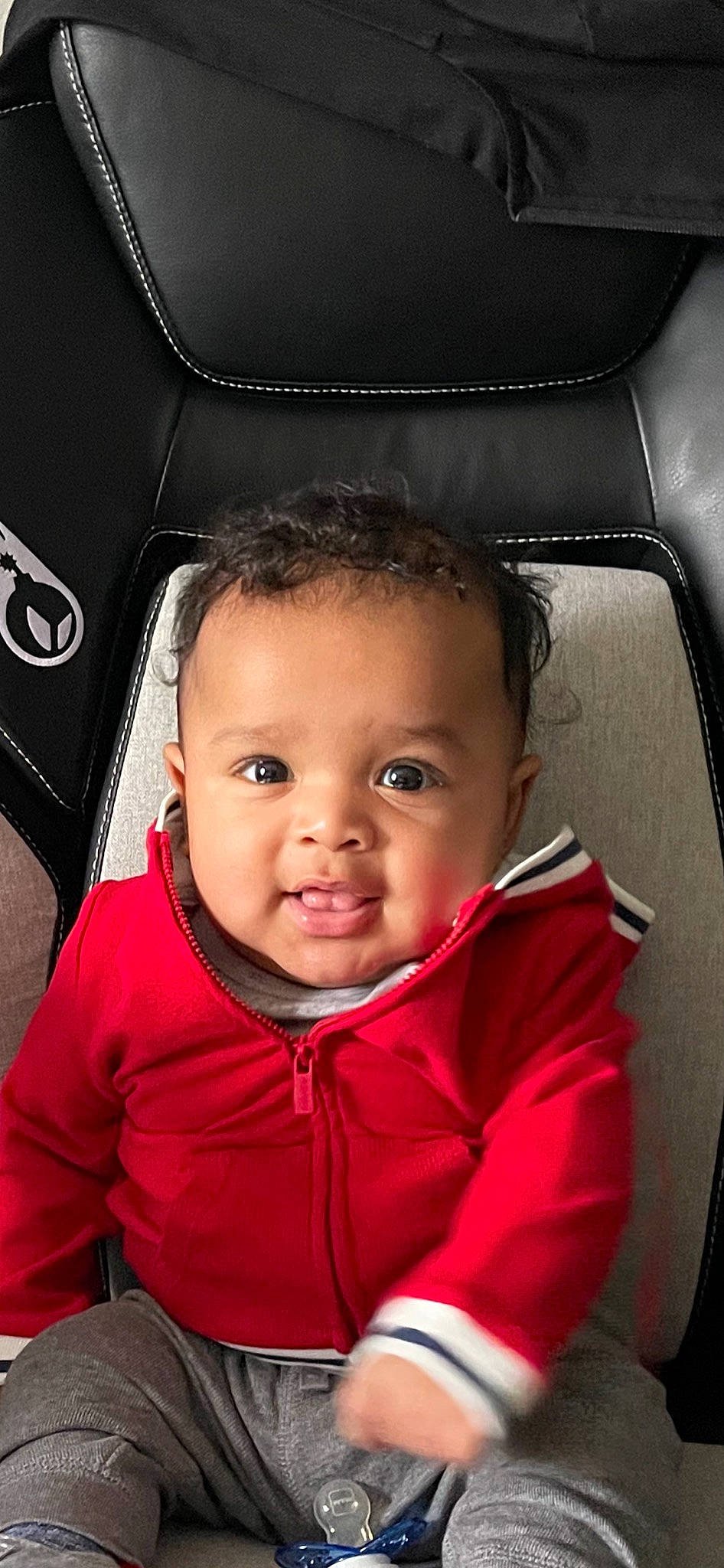 Luca is registered to the contest to win money with this photo: auto_part, automotive_design, baby, car_seat, cheek, child, chin, face, flash_photography, fun, gesture, happy, jacket, mouth, nose, person, skin, sleeve, smile, toddler