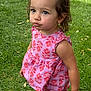 toddler, child, girl, pink_dress, floral_pattern, grass, outdoor, cute, pout, curious, portrait, summer, nature, playful, young_child, person, barefoot, daylight, expression, short_hair