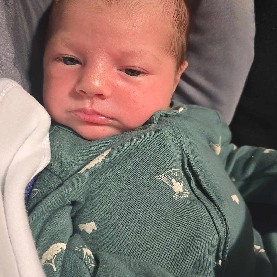 Sonic joined the competition — help win amazing prizes! baby, blanket, child, closeup, cozy, cute, expression, face, green_clothing, head, indoors, infant, newborn, onesie, portrait, resting, skin, sleepy, soft_light, young