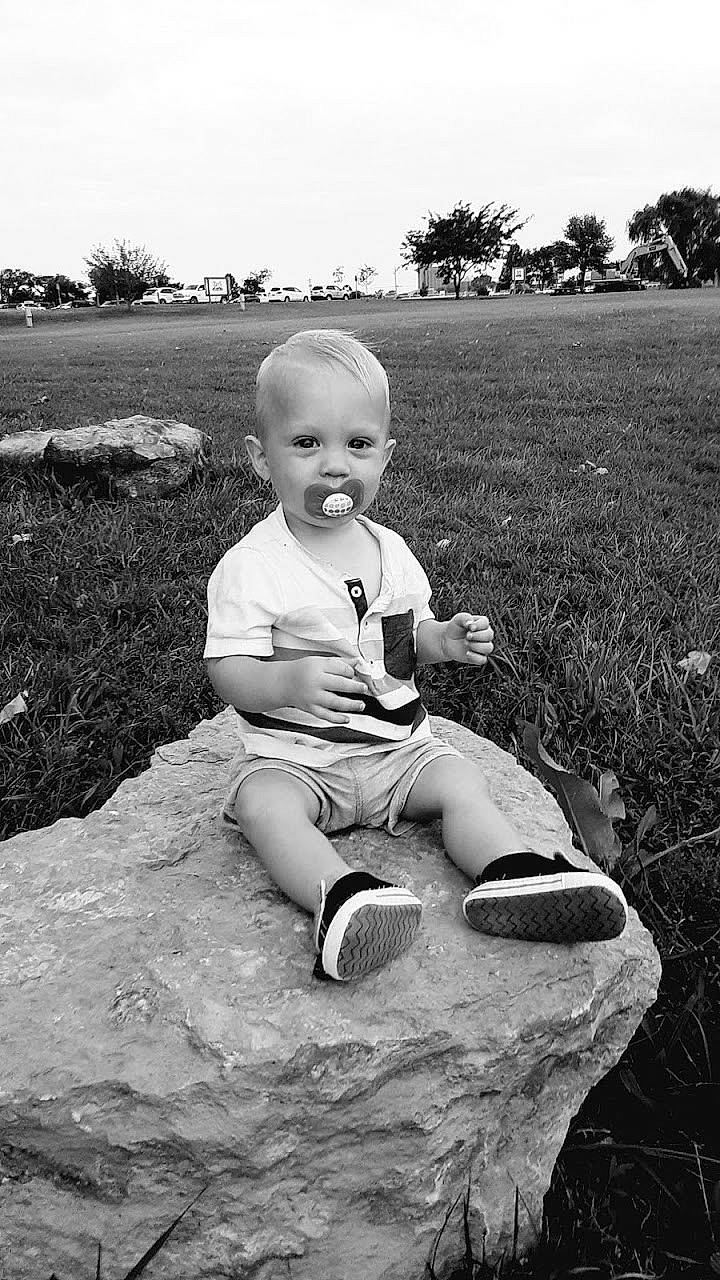 Jensen is registered to the contest to win money with this photo: baby, black, black_and_white, child, eye, fun, grass, leg, monochrome, monochrome_photography, people, person, photograph, photography, sitting, snapshot, standing, stock_photography, toddler, tree