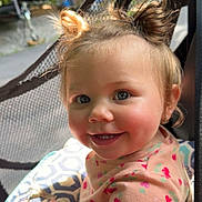 Ainsley is registered to the contest to win money with this photo: toddler, child, smiling, hair_buns, blue_eyes, face, cute, outdoor, mesh, patterned_clothing, cherry_print, cushion, baby, happy, portrait, infant, person, soft_lighting, closeup, playful
