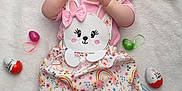 Ilona a rejoint le concours — aidez-le/la à gagner de superbes lots ! baby, child, sunglasses, headband, bow, blanket, easter_eggs, pink_clothing, floral_pattern, bunny_design, pastel_colors, cute, infant, laying_down, decorations, holiday, celebration, soft_texture, footwear_free, happy