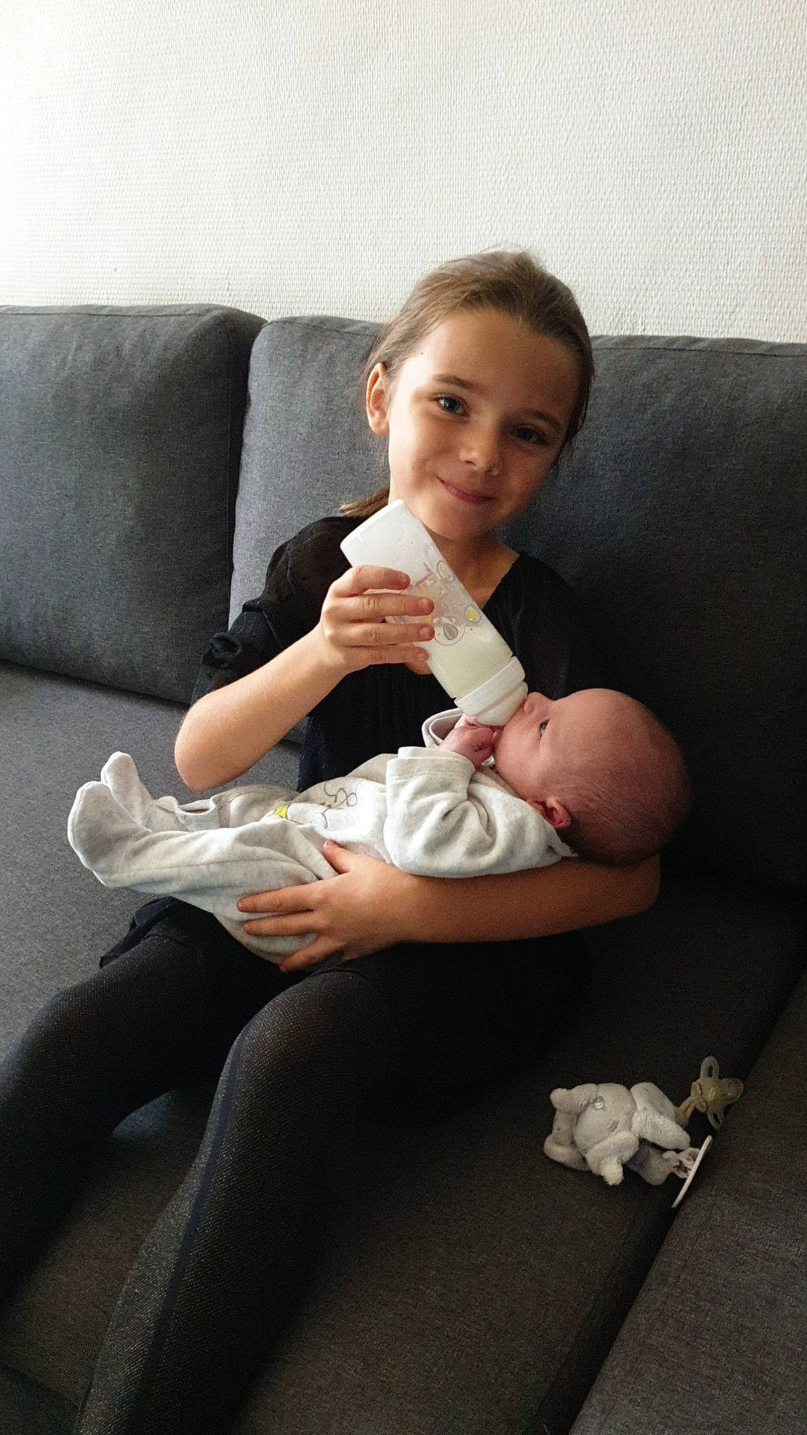 Mailee participe au concours pour gagner de l'argent avec cette photo : armrest, baby, baby_toddler_clothing, child, comfort, couch, finger, foot, hand, joy, lap, living_room, love, person, sock, sofa_bed, thumb, toddler