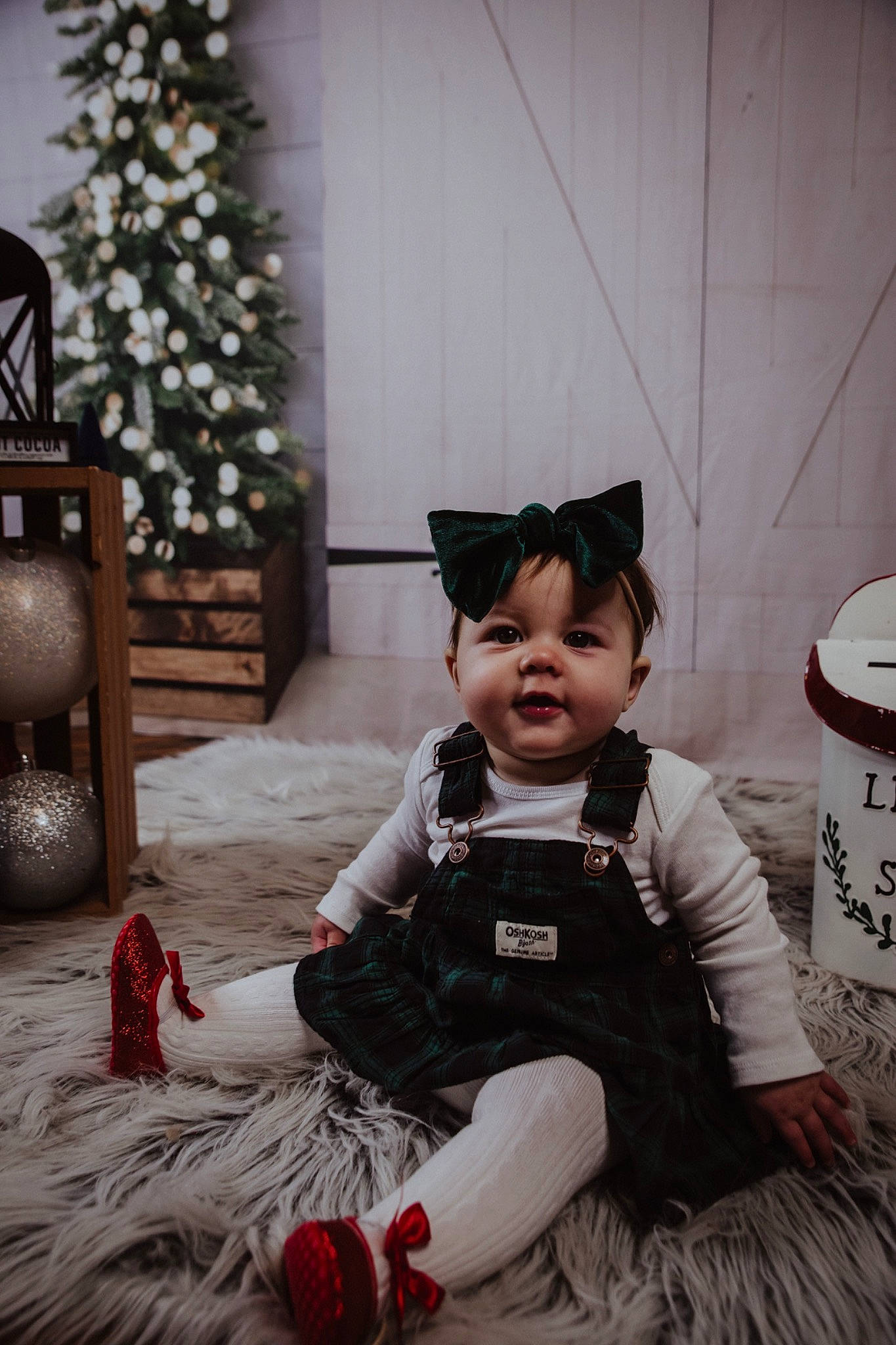 Eleanor is registered to the contest to win money with this photo: baby, baby_toddler_clothing, carmine, child, christmas_tree, costume_hat, event, flooring, fun, fur, happy, hat, holiday, person, room, sitting, toddler, toy, tree, white