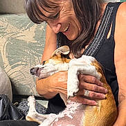 Suzy Q is registered to the contest to win money with this photo: affection, black_clothing, casual, comfort, couch, dog, domestic, face, hair, hand, happy, holding, indoor, love, pet, relaxation, ring, smiling, sunglasses, woman