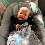 Maddy a rejoint le concours — aidez-le/la à gagner de superbes lots ! baby, infant, smiling, bouncer, seat, blanket, pacifier, beads, plaid, black_sweater, hand, face, head, portrait, indoors, pillow, cozy, newborn, toy, closeup