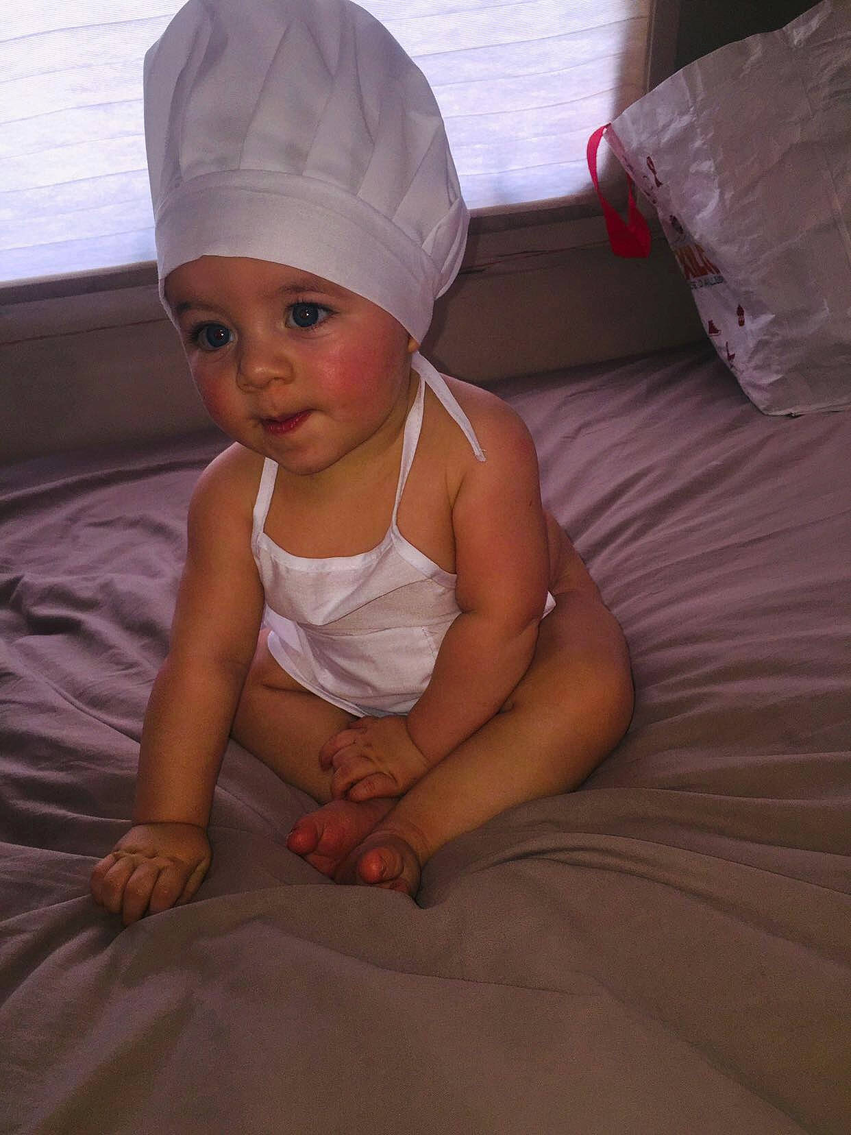 Yvann a rejoint le concours — aidez-le/la à gagner de superbes lots ! baby, baby_toddler_clothing, cap, chin, comfort, costume_hat, elbow, eye, finger, flash_photography, hat, head, headgear, headwear, human_body, linens, neck, person, pink, sleeve