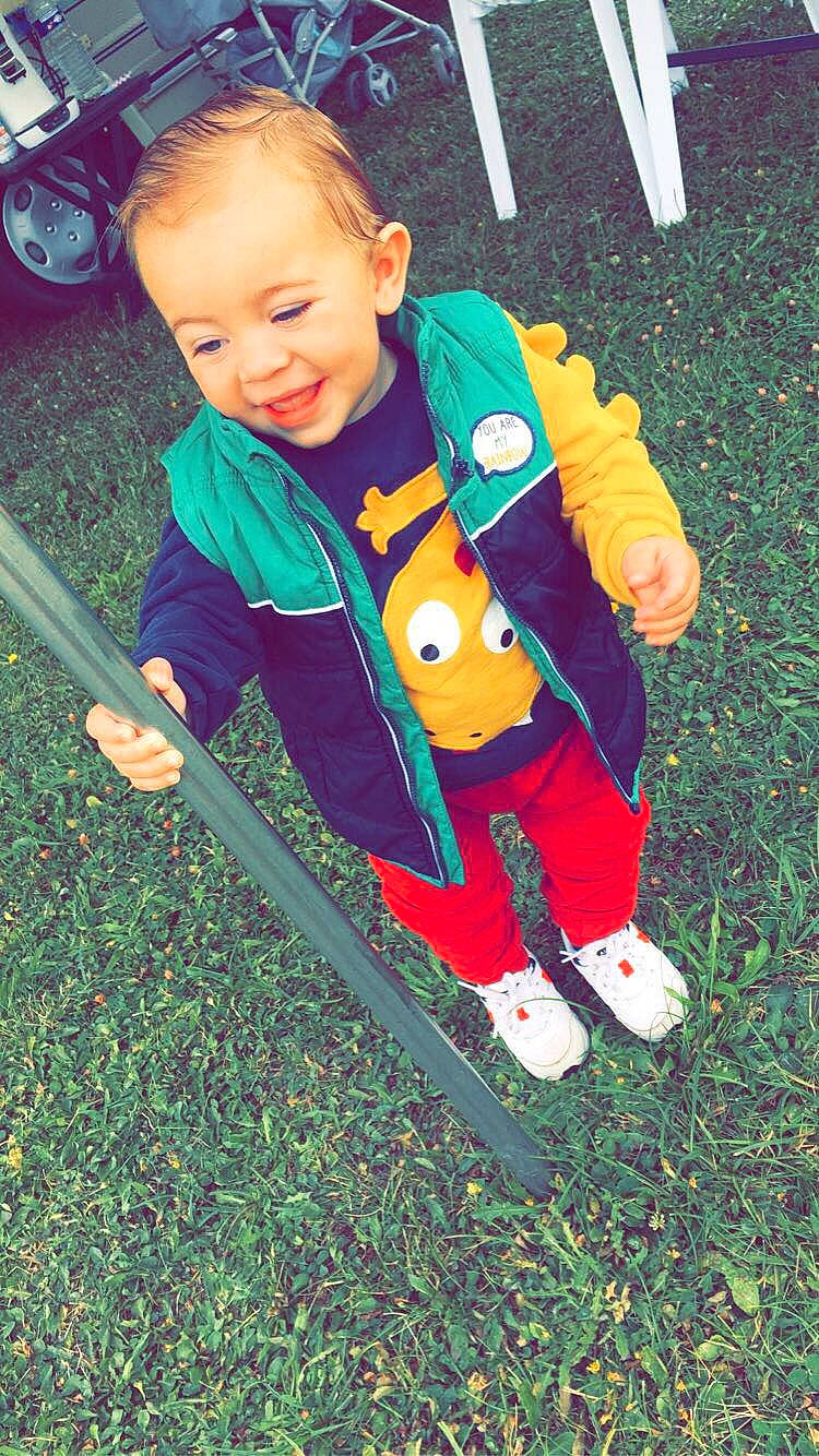 Yvann a rejoint le concours — aidez-le/la à gagner de superbes lots ! baby, baby_products, baby_toddler_clothing, bicycle_wheel, child, face, fun, grass, happy, holiday, joy, leisure, people_in_nature, person, play, recreation, sitting, sleeve, smile, tire