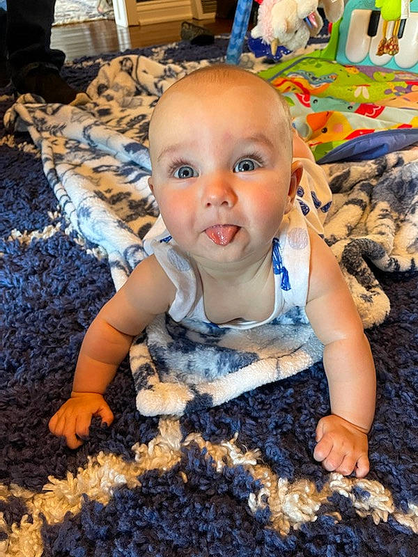 Brynn is registered to the contest to win money with this photo: baby, baby_products, baby_toddler_clothing, blue, cheek, child, flooring, fun, happy, iris, mouth, people_in_nature, person, play, room, sitting, soil, toddler, toy, wood
