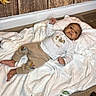 Ryan joined the competition — help win amazing prizes! baby, infant, child, smiling, portrait, lying_down, blanket, white_clothing, onesie, baby_clothes, pajamas, bed, cozy, indoor, autumn_decorations, wooden_background, nursery, happy, sleeping_area, photography