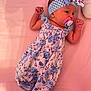 Rachel joined the competition — help win amazing prizes! baby, infant, pacifier, headband, floral_clothing, blue, white, pink_background, cute, sleepwear, newborn, child, soft_surface, lying_down, portrait, small_hands, fashion, resting, indoors, person