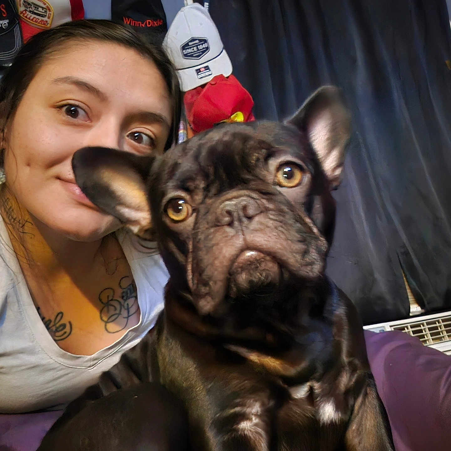 Nutella is registered to the contest to win money with this photo: woman, dog, french_bulldog, pet, selfie, tattoo, indoor, curtain, hat, face, smile, closeup, animal, person, furniture, room, casual, portrait, cute, companion