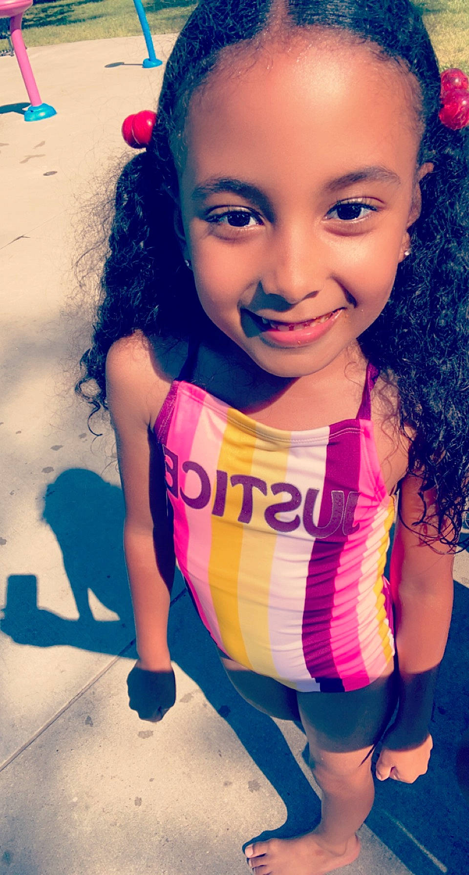 Justice is registered to the contest to win money with this photo: arm, blue, cheek, clothing, dress, eyebrow, eyelash, face, hair, hairstyle, happy, head, human_body, joy, lip, neck, person, pink, shoulder, skin