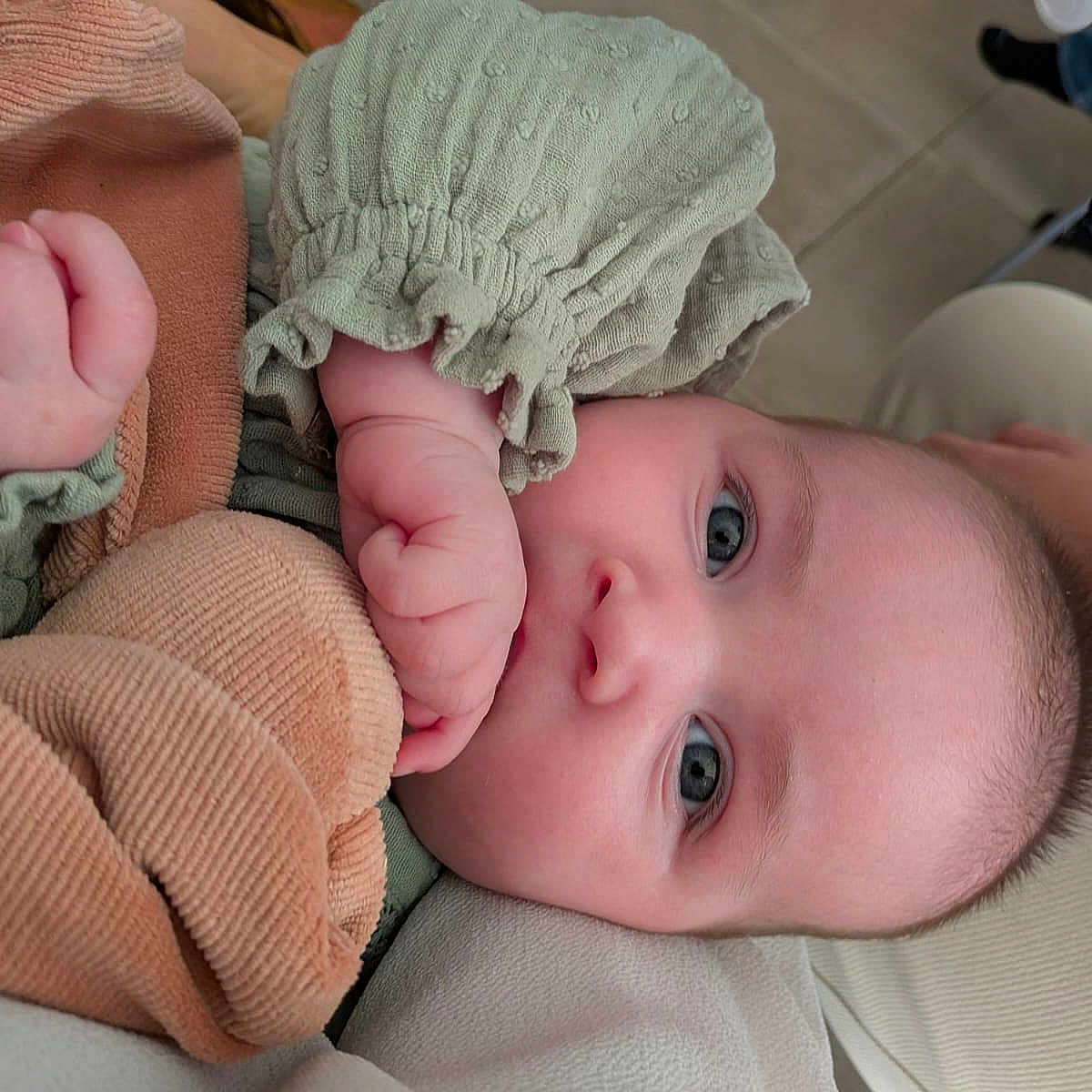 Leia a rejoint le concours — aidez-le/la à gagner de superbes lots ! baby, blue_eyes, child, closeup, clothing, comfort, cute, fabric, face, fist, green_outfit, hand, indoors, infant, person, portrait, resting, skin, soft_surface, texture