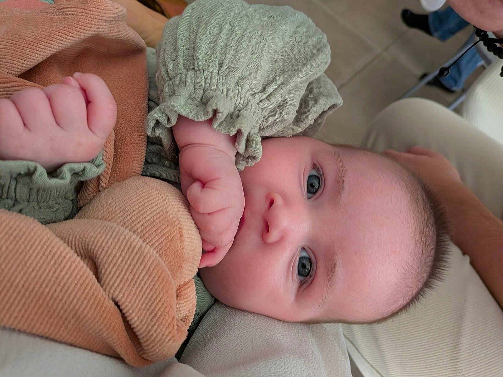 Leia a rejoint le concours — aidez-le/la à gagner de superbes lots ! baby, infant, child, face, blue_eyes, hand, fist, clothing, green_outfit, texture, fabric, resting, closeup, portrait, soft_surface, cute, skin, person, indoors, comfort