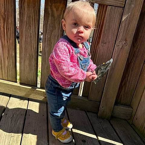Michaela is registered to the contest to win money with this photo: baby, baby_products, baby_toddler_clothing, cheek, child, denim, fun, grass, happy, hardwood, leisure, magenta, outdoor_shoe, pattern, person, pink, sitting, sleeve, toddler, vacation