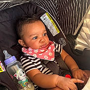 Nevaeh joined the competition — help win amazing prizes! baby, child, car_seat, bottle, bib, striped_clothing, hand, face, infant, seatbelt, cute, indoors, curious, young_child, black_hair, patterned_fabric, sitting, closeup, safety, adorable