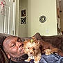 Ms Minnie joined the competition — help win amazing prizes! man, dog, pet, indoor, couch, living_room, relaxing, brown_fur, bow, wall_decor, blanket, facial_hair, casual_clothing, home, comfort, portrait, small_dog, cute, resting, close_up