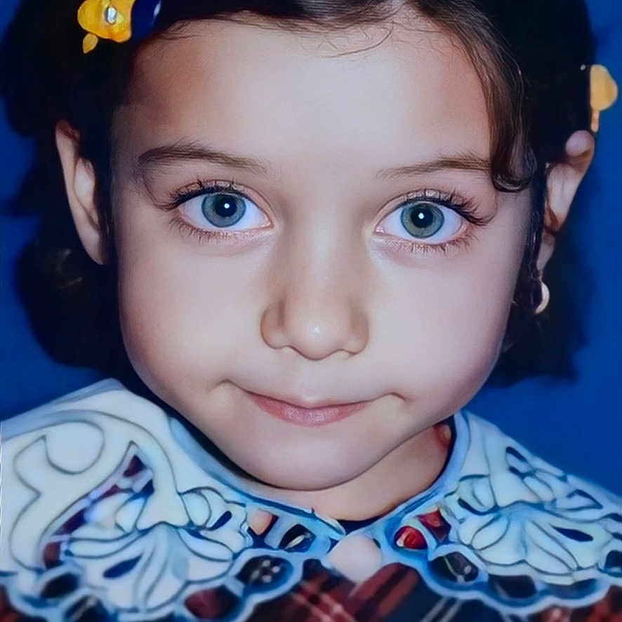Cemre a rejoint le concours — aidez-le/la à gagner de superbes lots ! blue_background, blue_eyes, child, childhood, close_up, cute, dark_hair, dress, eyelashes, face, fashion, hair_clip, headshot, innocence, lace_collar, patterned_clothing, portrait, smile, studio_photo, young_girl
