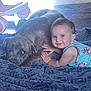 baby, dog, blanket, indoor, floor, child, pet, smiling, blue_eyes, floral_dress, snuggling, cute, happy, animal, friendship, comfort, laying_down, fur, playful, toddler