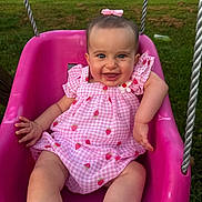 Stella is registered to the contest to win money with this photo: baby, child, swing, pink, dress, bow, smile, outdoor, grass, playground, happy, infant, cute, summer, portrait, seat, person, cheerful, gingham, strawberry