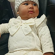 Tiffany Hernandez is registered to the contest to win money with this photo: automobile, baby, bow, car_seat, child, cute, expression, face, fashion, indoor, infant, knit_hat, long_sleeves, photography, pom_pom, portrait, sitting, vehicle, white_outfit, winter_clothing