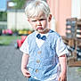 Rémy participe au concours pour gagner de l'argent avec cette photo : blond_hair, blue_eyes, blue_vest, blurred_background, bow_tie, boy, casual_clothing, child, daylight, garden, jeans, outdoor, pavement, person, portrait, serious_expression, standing, sunny, toddler, white_tshirt
