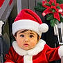 adorable, baby, celebration, child, christmas, cute, face, festive, greenery, holiday, infant, portrait, red_background, red_hat, santa_claus_costume, seasonal, stroller, white_fur_trim, winter_clothing, young_child