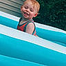 Myles joined the competition — help win amazing prizes! child, toddler, baby, smiling, laughing, red_hair, outdoor, swimming_pool, inflatable_pool, summer, water, tank_top, portrait, face, happy, playful, backyard, house, greenery, sunlight